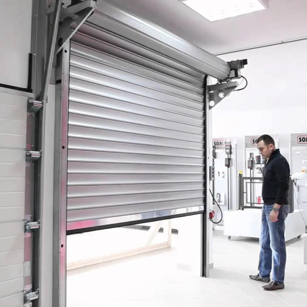Puerta enrollable automática de aluminio instalada en entorno comercial o industrial