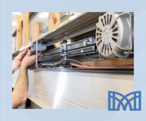 Técnico realizando el mantenimiento del motor de una puerta automática